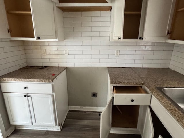 kitchen with open shelves, wood finished floors, backsplash, and white cabinetry