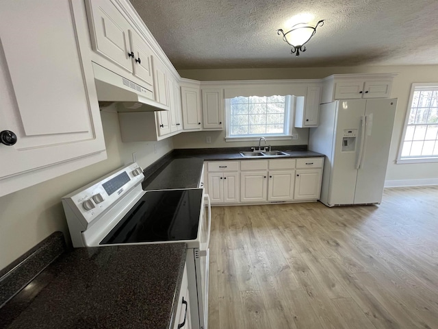 kitchen featuring white refrigerator with ice dispenser, a sink, electric stove, light wood-type flooring, and dark countertops