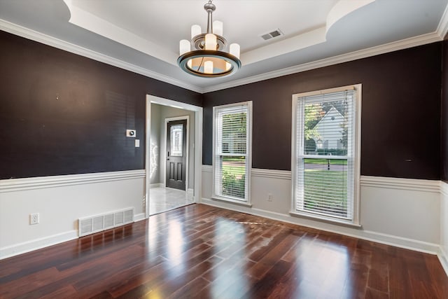 unfurnished room featuring a wainscoted wall, visible vents, a raised ceiling, and wood finished floors