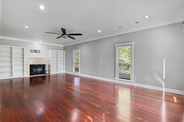 unfurnished living room featuring crown molding, baseboards, a tiled fireplace, and wood finished floors