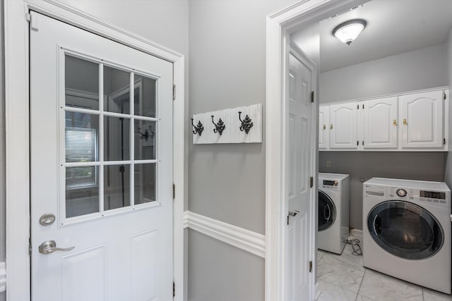 washroom with marble finish floor, cabinet space, and washer and clothes dryer