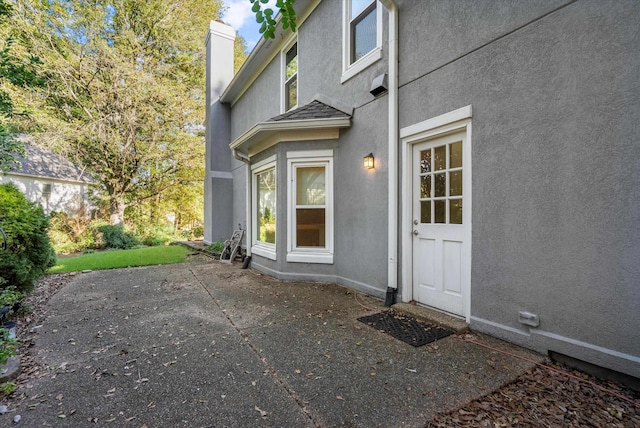 entrance to property with a patio area and stucco siding