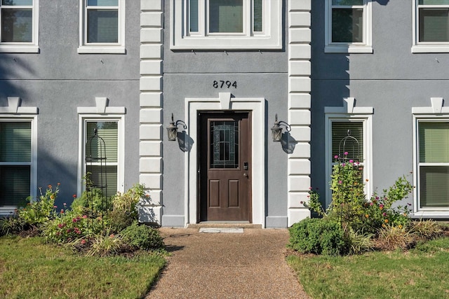 property entrance with stucco siding