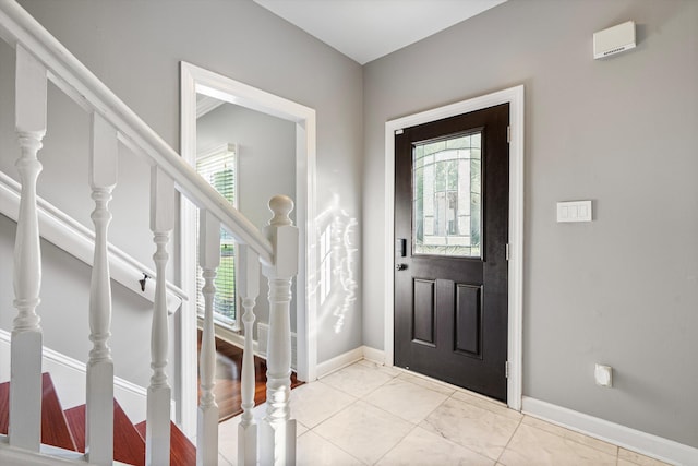 entrance foyer with plenty of natural light, stairway, and baseboards