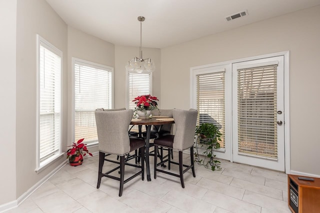 dining space with light tile patterned floors, visible vents, and baseboards