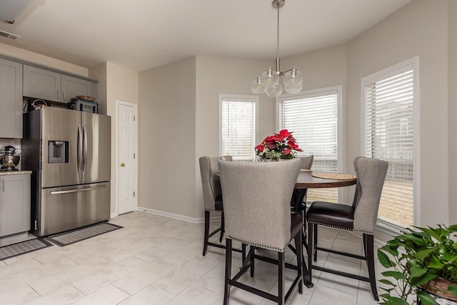 dining area featuring visible vents, baseboards, and a chandelier