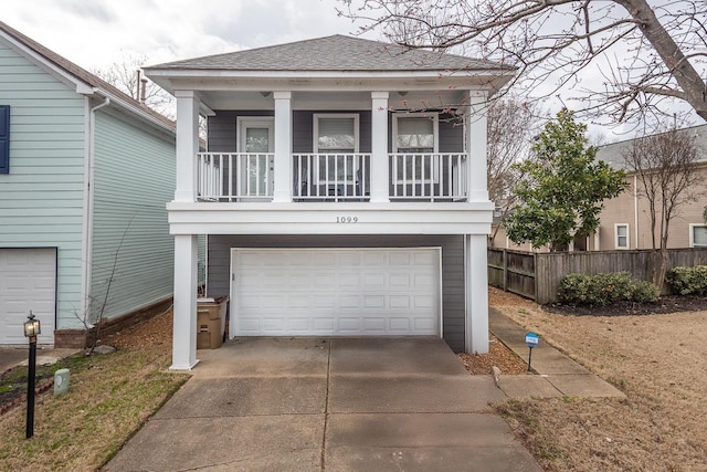 view of front of property featuring concrete driveway, a shingled roof, an attached garage, and fence