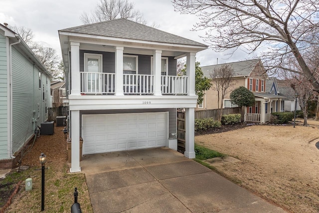 view of front of property with a shingled roof, cooling unit, a porch, and driveway