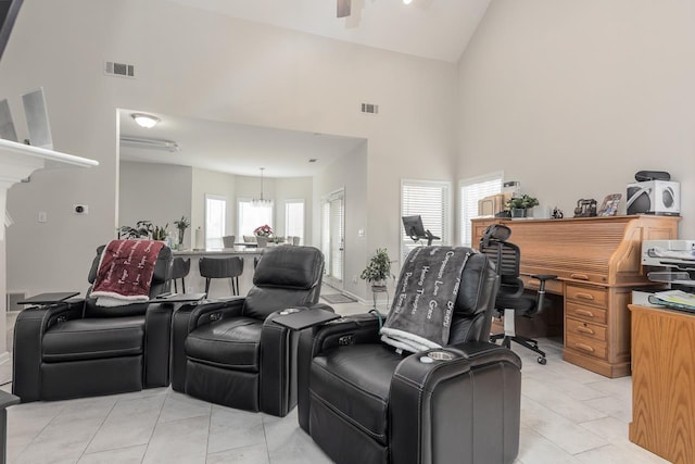 home theater featuring high vaulted ceiling, light tile patterned flooring, and visible vents