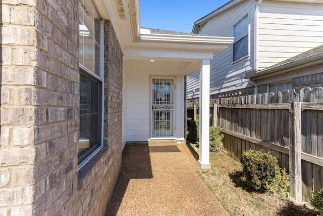 view of exterior entry featuring fence