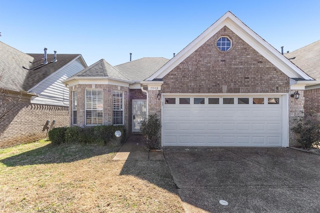 view of front of home with brick siding, a shingled roof, a garage, driveway, and a front lawn