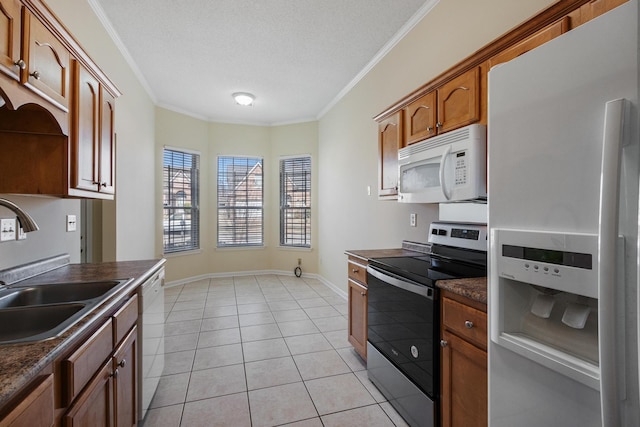 kitchen featuring white appliances, light tile patterned floors, baseboards, dark countertops, and crown molding