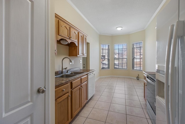 kitchen featuring ornamental molding, white appliances, dark countertops, and a sink