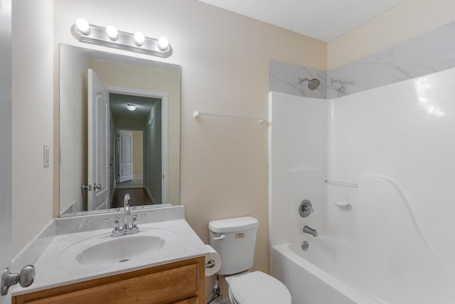 full bathroom featuring washtub / shower combination, vanity, and toilet