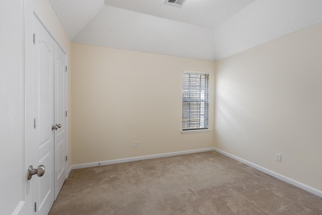 unfurnished bedroom with visible vents, baseboards, carpet, vaulted ceiling, and a closet