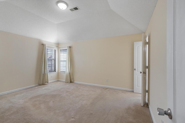 unfurnished room with lofted ceiling, baseboards, light carpet, and visible vents