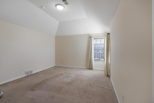 bonus room with vaulted ceiling, baseboards, visible vents, and light colored carpet