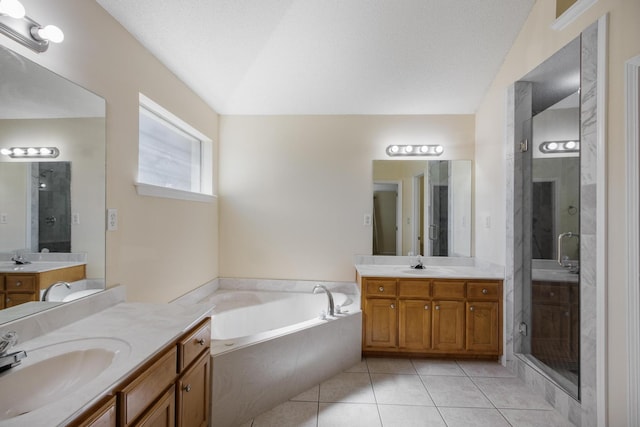 bathroom featuring a garden tub, a shower stall, a sink, and tile patterned floors