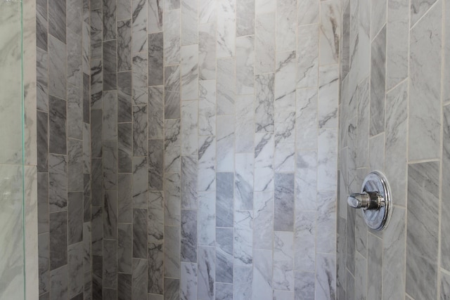 interior details featuring a tile shower