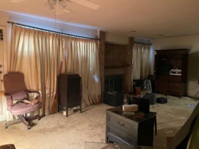 carpeted living room with a fireplace and a ceiling fan