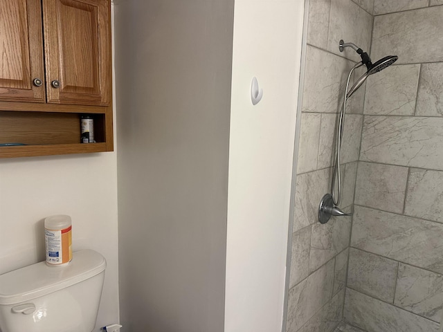 full bathroom featuring toilet and tiled shower