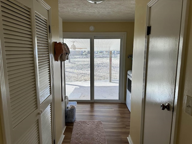 doorway featuring dark wood-style floors and a textured ceiling