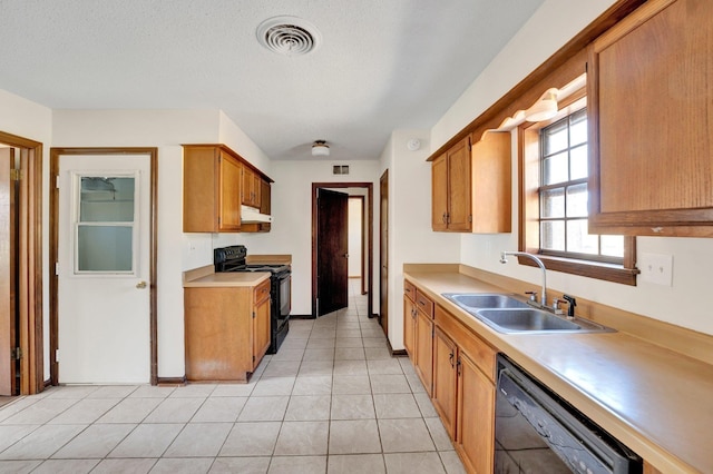 kitchen featuring visible vents, under cabinet range hood, light countertops, black appliances, and a sink