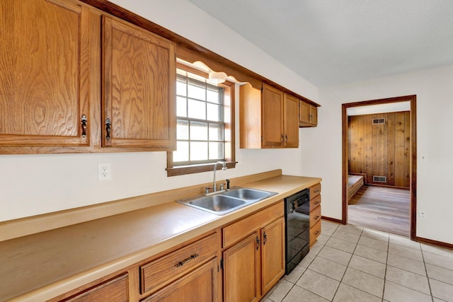 kitchen with light tile patterned floors, a sink, visible vents, black dishwasher, and brown cabinetry