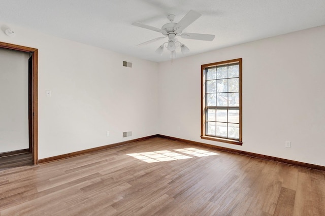 spare room featuring light wood-style floors, baseboards, and visible vents