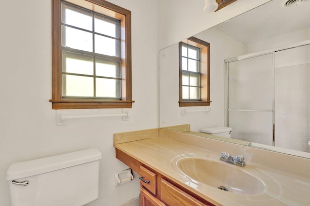 bathroom featuring plenty of natural light, vanity, toilet, and an enclosed shower