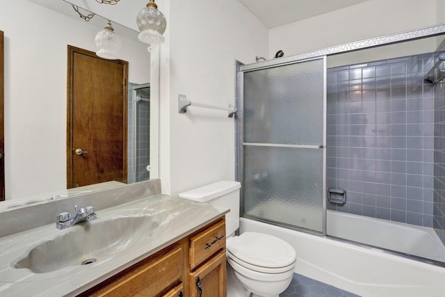 bathroom featuring toilet, bath / shower combo with glass door, and vanity