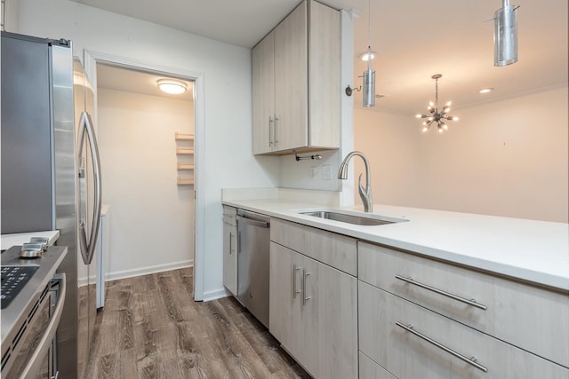 kitchen featuring stainless steel appliances, light countertops, dark wood-type flooring, and a sink