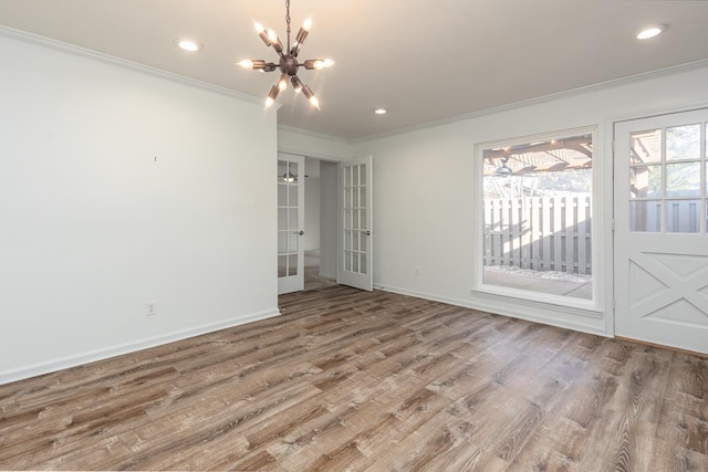 interior space featuring recessed lighting, wood finished floors, baseboards, ornamental molding, and an inviting chandelier