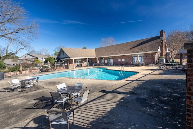 community pool featuring a patio and fence