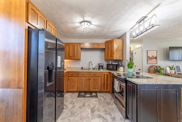 kitchen with stainless steel appliances, a sink, a peninsula, and light stone countertops