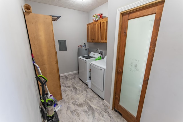 clothes washing area featuring a textured ceiling, baseboards, electric panel, cabinet space, and washing machine and clothes dryer