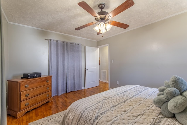 bedroom featuring crown molding, a textured ceiling, and wood finished floors