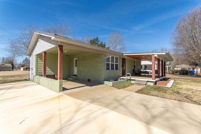 view of front facade with a carport, entry steps, concrete driveway, and brick siding