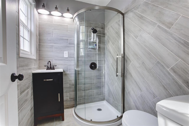 full bath with toilet, a shower stall, and tile walls