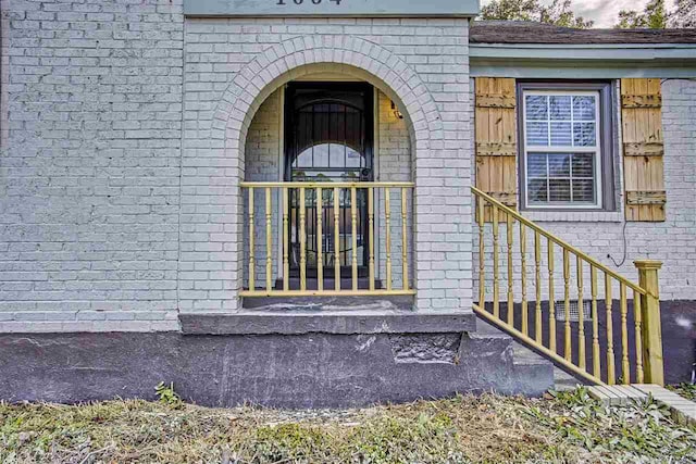 view of exterior entry featuring brick siding