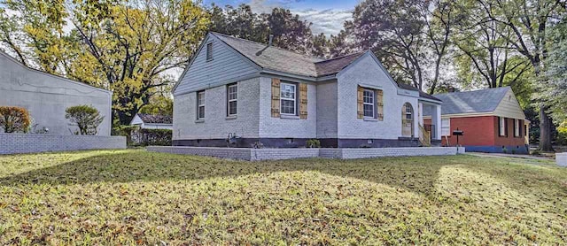 view of property exterior with brick siding and a yard