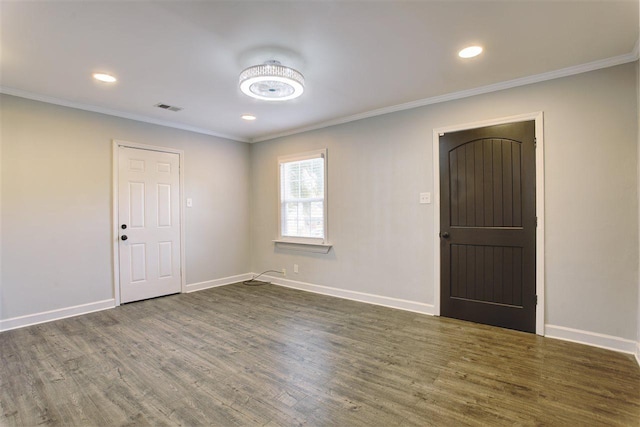 unfurnished room featuring ornamental molding, dark wood finished floors, visible vents, and baseboards