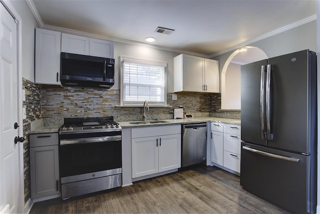 kitchen featuring stainless steel appliances, visible vents, a sink, and light stone countertops