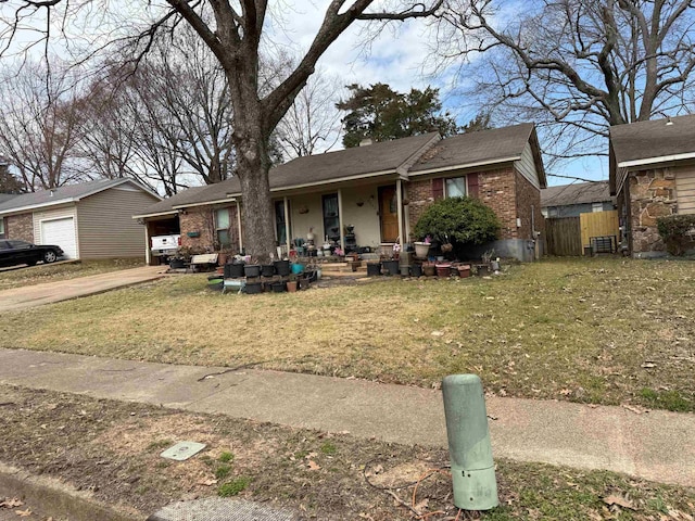 view of front of property featuring brick siding, a front yard, fence, and an outdoor structure