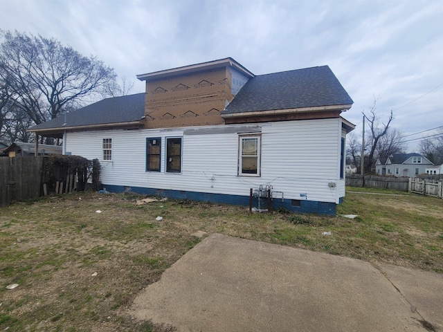 rear view of property with crawl space, fence, a lawn, and roof with shingles