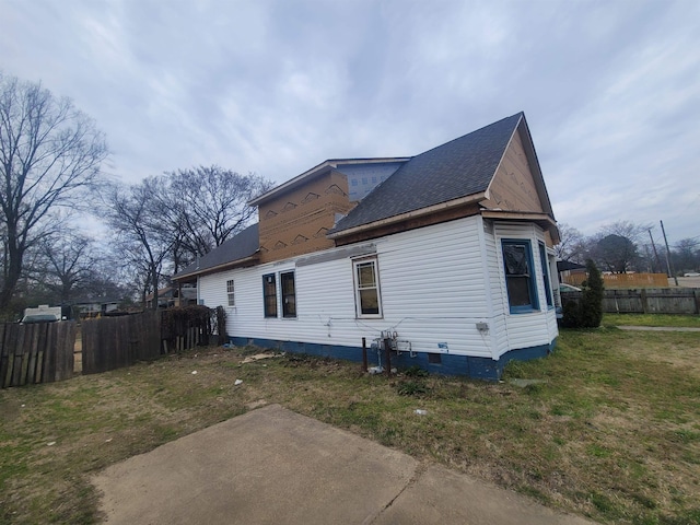 view of property exterior featuring crawl space, fence, and a lawn