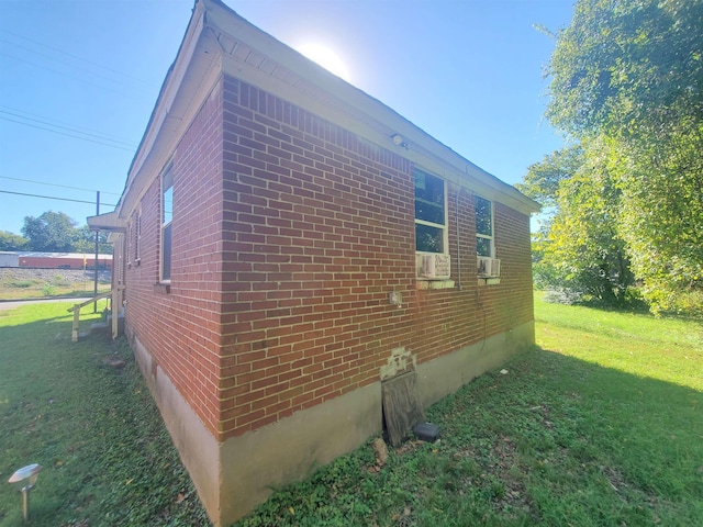 view of side of home featuring a yard and brick siding