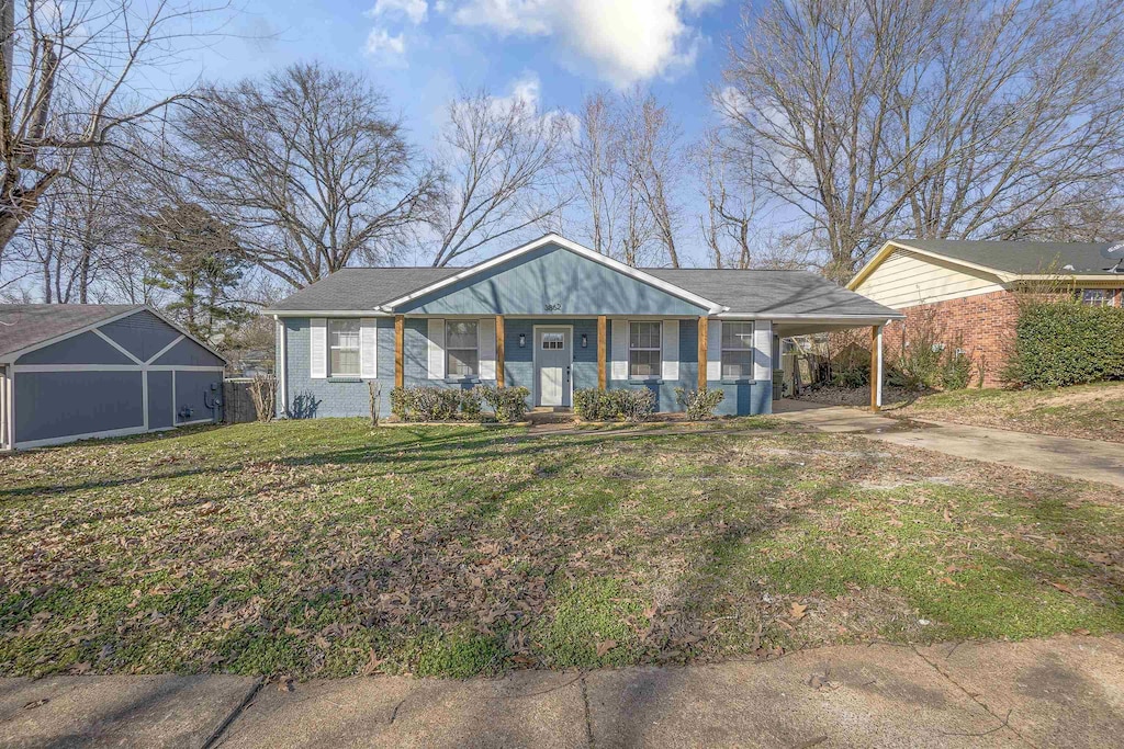 view of front of home featuring driveway, a front lawn, and brick siding