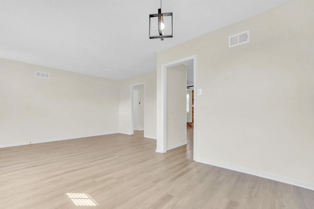 unfurnished room with light wood-style floors, baseboards, and visible vents