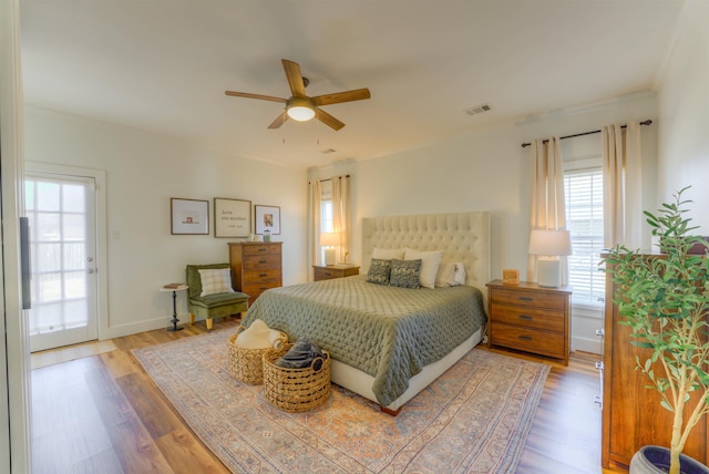 bedroom with visible vents, ceiling fan, baseboards, and wood finished floors